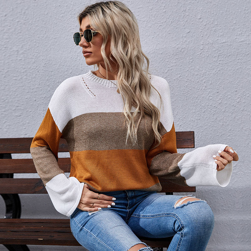 Woman wearing color-block sweater in white, brown, and mustard tones