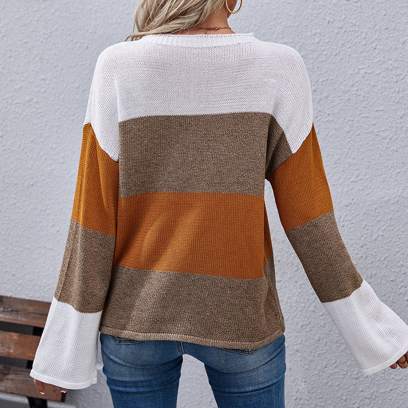 Woman wearing color-block sweater in white, brown, and mustard tones