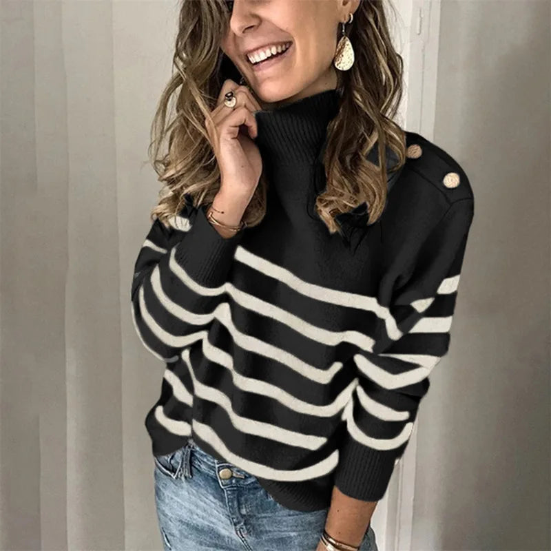 Woman wearing a black and white striped sweater with a plain background