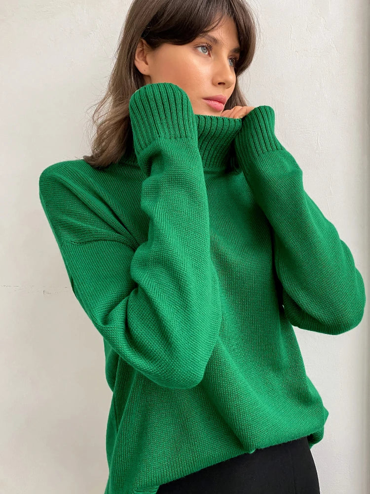 Woman wearing a green sweater against a plain background