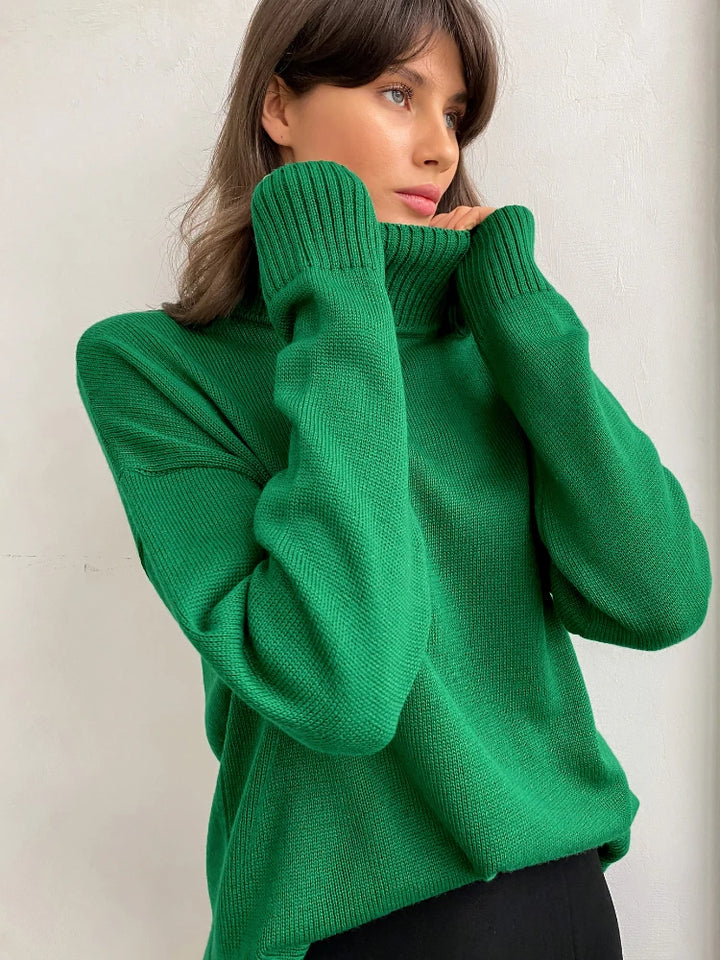 Woman wearing a green sweater against a plain background